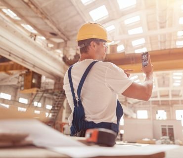 Male worker taking building photo with modern smartphone